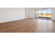 Spacious living room with wood-look tile flooring, white walls, and a sliding glass door at 4244 E Bradford Ave, San Tan Valley, AZ 85140