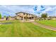 Expansive backyard with lush lawn, trampoline, playground, and mature trees at 5312 N Sierra Hermosa Ct, Litchfield Park, AZ 85340