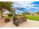 Whimsical backyard seating with custom iron benches and table with wagon wheel detail, great for entertaining at 5312 N Sierra Hermosa Ct, Litchfield Park, AZ 85340