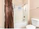 Bathroom featuring a white bathtub and toilet with brown shower curtain at 5312 N Sierra Hermosa Ct, Litchfield Park, AZ 85340