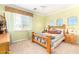 Cozy bedroom with neutral green walls, a wood-framed bed, carpet, and shuttered windows to let in natural light at 5312 N Sierra Hermosa Ct, Litchfield Park, AZ 85340