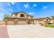 Expansive home showcasing a large driveway, desert landscaping, and a three-car garage at 5312 N Sierra Hermosa Ct, Litchfield Park, AZ 85340