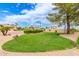 Beautifully landscaped front yard with green grass, desert landscaping, and well-manicured shrubs at 5312 N Sierra Hermosa Ct, Litchfield Park, AZ 85340