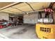 Functional garage space with ample storage, tools, equipment, and a yellow forklift at 5312 N Sierra Hermosa Ct, Litchfield Park, AZ 85340