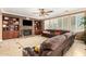Spacious living room featuring a stone fireplace, built-in shelves, and comfortable leather seating at 5312 N Sierra Hermosa Ct, Litchfield Park, AZ 85340