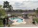 Aerial view of a backyard featuring a pool, BBQ area, and palm trees, perfect for outdoor living at 5312 N Sierra Hermosa Ct, Litchfield Park, AZ 85340