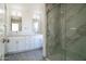 Modern bathroom featuring double sinks, white cabinets, and a glass shower enclosure at 9127 W Banff Ln, Peoria, AZ 85381