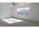 Well-lit bedroom with large window, ceiling fan, and neutral carpet at 9127 W Banff Ln, Peoria, AZ 85381