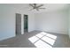 Bright bedroom with ceiling fan, carpeting, and ensuite bathroom access at 9127 W Banff Ln, Peoria, AZ 85381