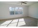 Spacious bedroom with large window, ceiling fan, and neutral carpeting at 9127 W Banff Ln, Peoria, AZ 85381