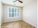 Bright bedroom featuring wood-look floors, a ceiling fan, and a window with plantation shutters at 42531 W Heavenly Pl, Maricopa, AZ 85138