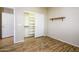Open-concept bedroom featuring wood-look floors and easy access to closet spaces at 42531 W Heavenly Pl, Maricopa, AZ 85138