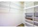Walk-in closet with white shelving, metal rods, and wood-look floors provides ample storage space at 42531 W Heavenly Pl, Maricopa, AZ 85138