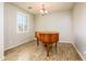 Light-filled dining room showcasing wood-look floors, a stylish chandelier, and a grand piano at 42531 W Heavenly Pl, Maricopa, AZ 85138
