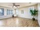 Spacious living room with wood-look floors, plantation shutters, a ceiling fan, and neutral paint at 42531 W Heavenly Pl, Maricopa, AZ 85138