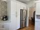Charming kitchen featuring white cabinets, stainless steel refrigerator, and decorative backsplash at 73 W Lewis Ave, Phoenix, AZ 85003