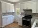 Bright kitchen featuring white cabinets, stainless steel oven, and decorative tile backsplash at 73 W Lewis Ave, Phoenix, AZ 85003