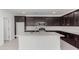 This kitchen features a large island with a sink, stainless steel appliances, and dark cabinets at 4505 S Mole --, Mesa, AZ 85212