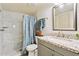 Bright bathroom featuring granite countertop vanity and white marble shower with patterned blue shower curtain at 15601 N 27Th St # 7, Phoenix, AZ 85032