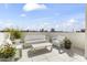 Inviting rooftop patio with white seating, lovely potted plants, and scenic city views at 312 E Windsor Ave # 11, Phoenix, AZ 85004