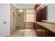 A luxurious bathroom features a glass enclosed walk-in shower with a built-in bench and dark wood cabinets at 41313 N Rolling Green Way, Anthem, AZ 85086