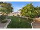 Large backyard with mature trees, grassy lawn and a circular gravel area at 4503 E Decatur St, Mesa, AZ 85205