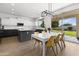 Modern kitchen with white and dark gray cabinets, eat-in area, and sliding door to backyard at 4503 E Decatur St, Mesa, AZ 85205