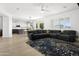 Open living room with black leather sectional and view into kitchen area at 4503 E Decatur St, Mesa, AZ 85205