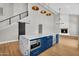 Open living area featuring wood floors and a kitchen island with blue cabinets and white countertops at 12222 N 74Th St, Scottsdale, AZ 85260
