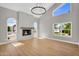 Bright living room with fireplace, wood floors, modern chandelier, and large windows at 12222 N 74Th St, Scottsdale, AZ 85260