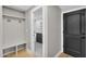 Mudroom featuring built-in bench and coat rack with access to a half bathroom with black and white tile at 12222 N 74Th St, Scottsdale, AZ 85260