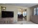 Cozy living room with a large TV and open access to the dining area at 17200 W Bell Rd # 569, Surprise, AZ 85374