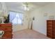 Bright bedroom featuring a ceiling fan, window, neutral carpet, and a mirror at 29922 N Little Leaf Dr, San Tan Valley, AZ 85143