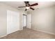 Bedroom with neutral carpet, ceiling fan, and closet with sliding doors at 3327 S Felix Way, Chandler, AZ 85248