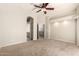 Spacious bedroom featuring neutral carpet, ceiling fan, and doorway to the ensuite bathroom at 3327 S Felix Way, Chandler, AZ 85248