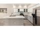 Kitchen with stainless steel refrigerator, an island with sink, and sleek white cabinets at 3327 S Felix Way, Chandler, AZ 85248