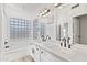 Bathroom featuring dual sinks, quartz countertops, tub and glass block window at 2390 S Walnut Dr, Chandler, AZ 85286