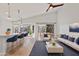 Open-concept living space with kitchen island seating and sliding doors to backyard patio at 2390 S Walnut Dr, Chandler, AZ 85286