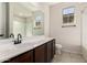 Modern bathroom featuring a large mirror, dark wood cabinets, and a combination tub and shower at 22882 E Marsh Rd, Queen Creek, AZ 85142