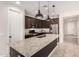 Well-lit kitchen with a granite island, modern appliances, and dark cabinets, offering a functional space at 22882 E Marsh Rd, Queen Creek, AZ 85142