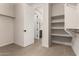 Walk-in closet with open doorway to bathroom and custom shelving at 22882 E Marsh Rd, Queen Creek, AZ 85142