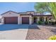 House exterior with a three-car garage and mature trees at 42608 N 46Th Ave, New River, AZ 85087