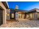 A modern home featuring a paver driveway, desert landscaping, and architectural lighting at 36323 N 100Th Way, Scottsdale, AZ 85262