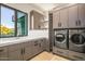Laundry room with front loading washer and dryer, ample cabinets, and a sink at 36323 N 100Th Way, Scottsdale, AZ 85262