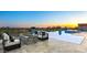 Outdoor entertainment area features modern fire pit and sparkling pool with beautiful sunset views at 36323 N 100Th Way, Scottsdale, AZ 85262