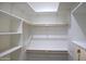 Bright, empty walk-in closet with white shelving and wooden rods; ready to be customized at 1527 E Germann Rd, San Tan Valley, AZ 85140