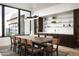 Modern dining room features a long table, wine storage, and a view to the outside at 28805 N 114Th St, Scottsdale, AZ 85262