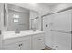 Modern bathroom featuring a double sink vanity, large mirror, and walk-in shower with glass doors at 18186 W Pima St, Goodyear, AZ 85338