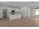 Open-concept kitchen featuring white cabinets, a center island with a sink, and modern appliances at 18186 W Pima St, Goodyear, AZ 85338