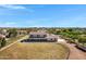 Aerial view of a home featuring a metal roof, fenced yard, surrounded by grassy fields and mature trees at 4880 E Beehive Rd, San Tan Valley, AZ 85140